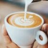 Cappuccino-Tasse von oben, Milch wird eingegossen, Latte-Art Tulpe sichtbar – ideal für Kaffee online bestellen.