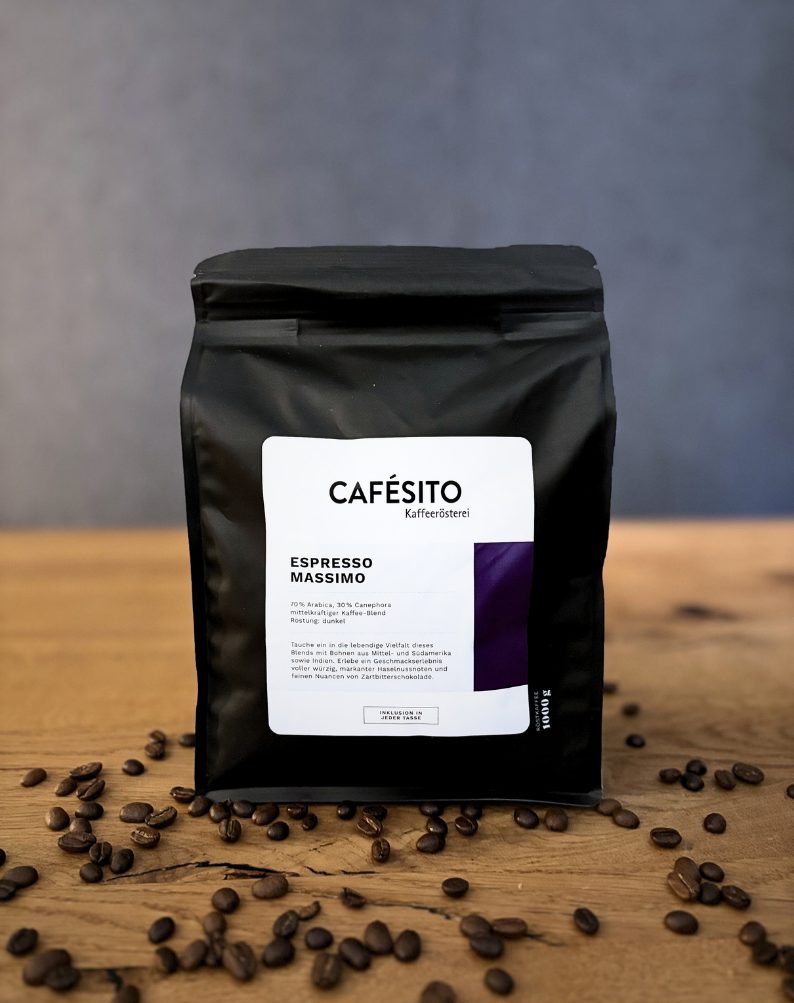 Espresso Massimo Kaffeeverpackung mit Aromaventil auf einem Tisch mit Kaffeebohnen drumherum.